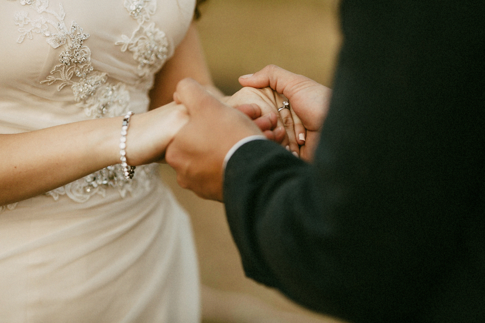 Groom holding bride's hands